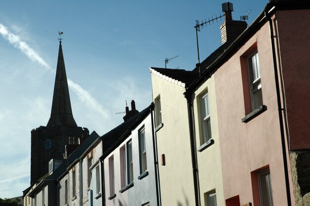 Low angle shot of of a tower near pink and blue assorted buildings