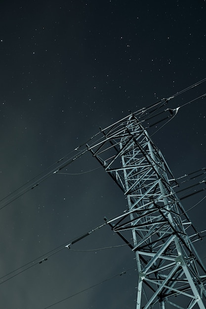 Low angle shot of a transmission tower under a starry sky