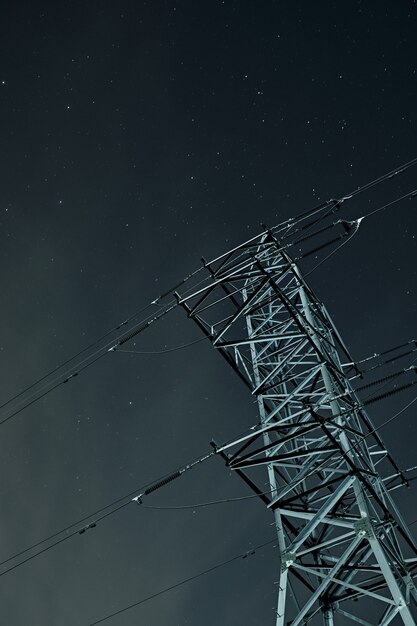 Low angle shot of a transmission tower under a starry sky