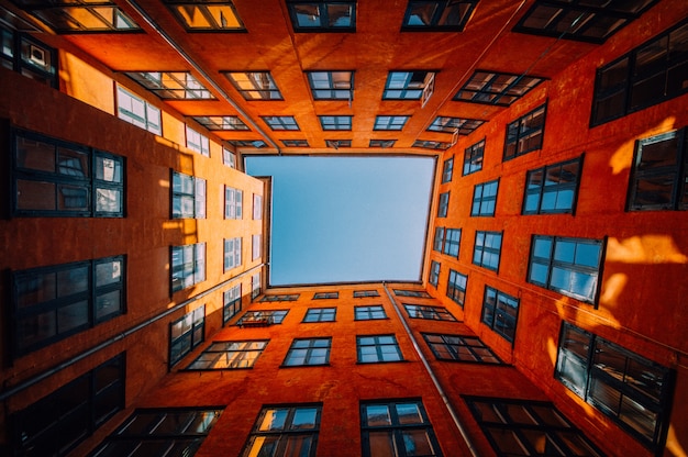하늘에 닿는 독특한 고층 주황색 건물의 낮은 각도 샷