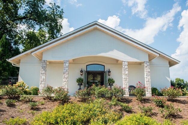 Low angle shot of a white church with a beautiful flower garden