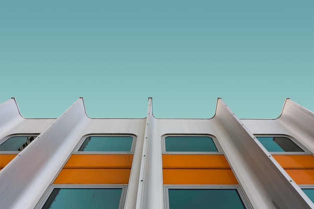 Low angle shot of a white and yellow modern building under the blue sky