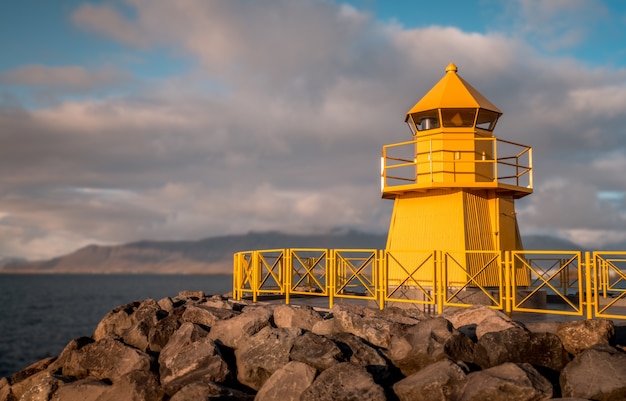 曇りの日に撮影された黄色の灯台のローアングルショット
