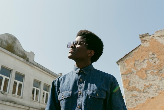 Free photo low angle smiley black man wearing sunglasses