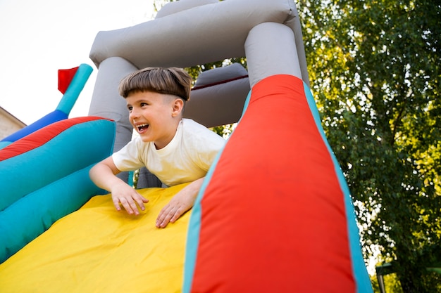 Free photo low angle smiley boy in bounce house