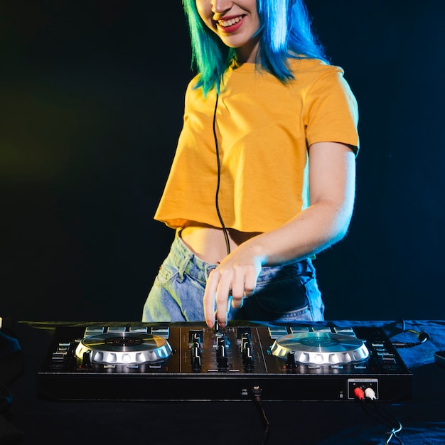 Low angle smiley dj woman mixing