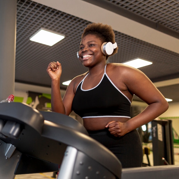 Low angle smiley female running on treadmill