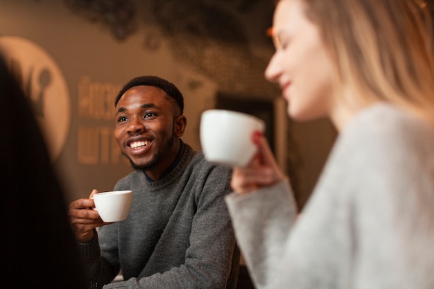 Low angle smiley friends drinking coffee