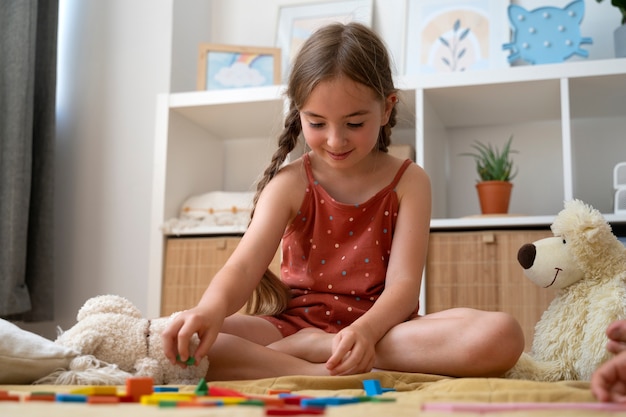 Low angle smiley girl making puzzle