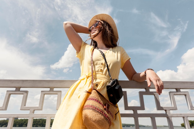 Free photo low angle smiley tourist posing