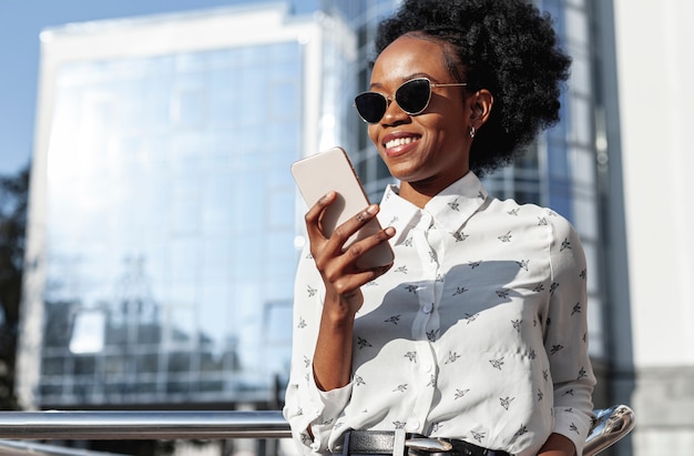 Low angle smiley woman looking at phone