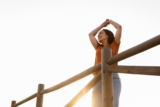 Low angle of smiley woman posing outdoors in nature