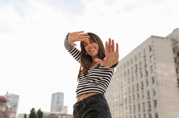 Free photo low angle smiley woman posing