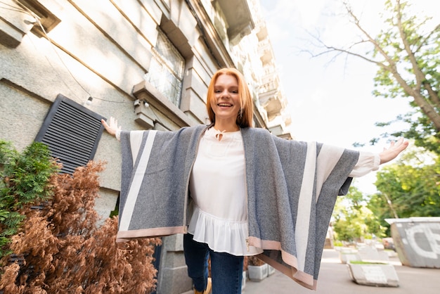 Free photo low angle smiley woman posing