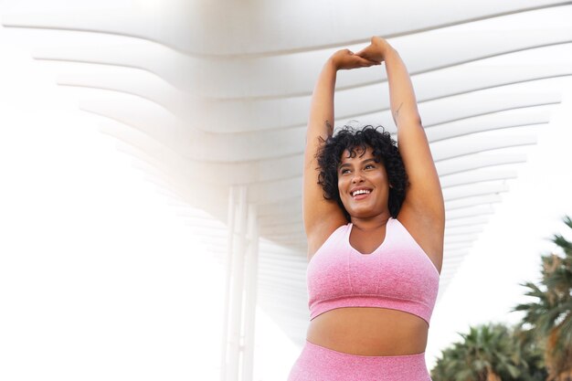 Low angle smiley woman stretching