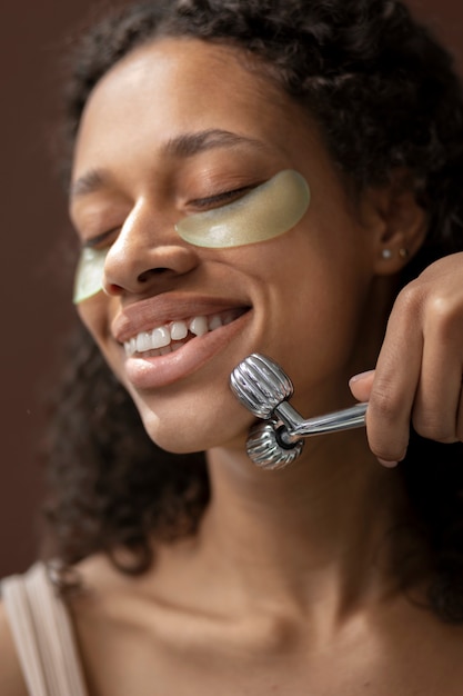 Low angle smiley woman using massage tool