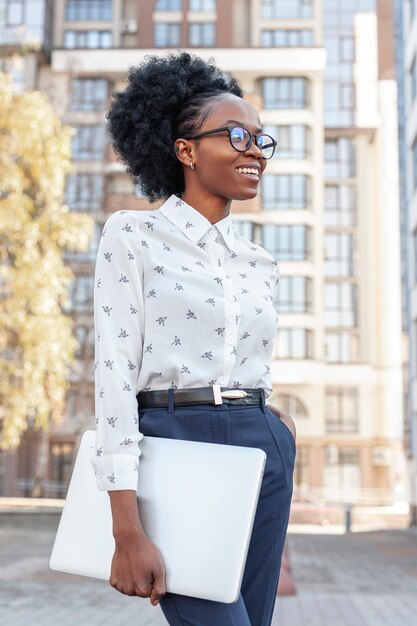 Low angle smiley woman with laptop