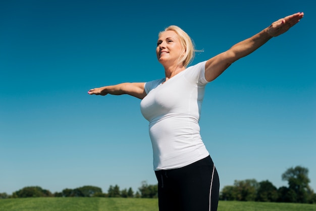 Low angle smiley woman with long arms