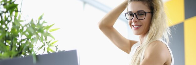 Low angle of smiling cheerful attractive businesswoman posing on sofa pretty company worker