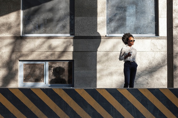 Low angle stylish female with coffee outdoor