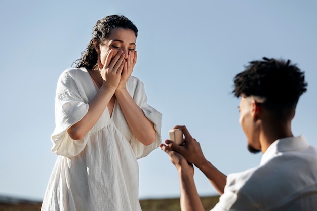 Free photo low angle surprised woman accepting proposal