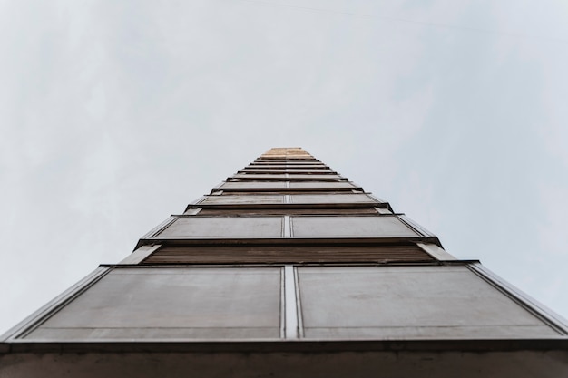 Free photo low angle of tall residential building in the city with copy space