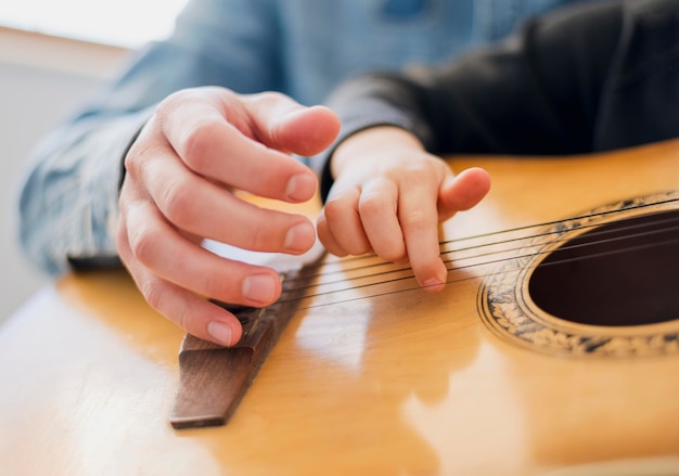 Low angle of teacher and child holding guitar