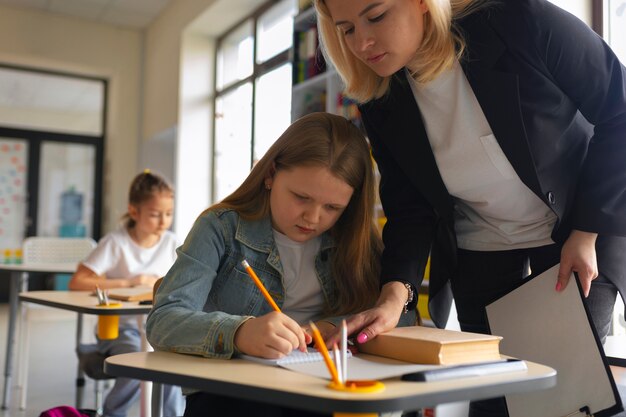 Low angle teacher helping kid