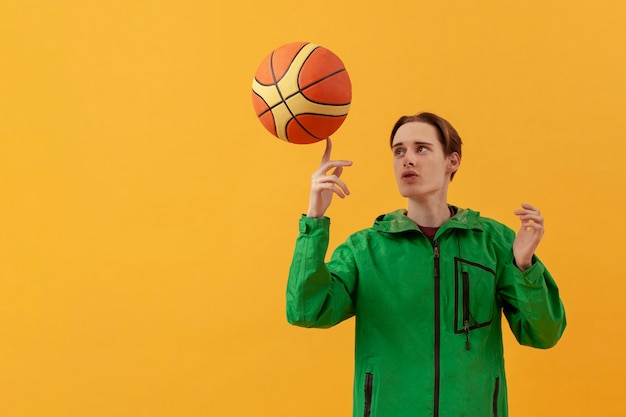 Free photo low angle teenager playing with basketball ball