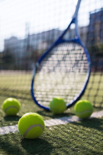 Low angle tennis balls and racket on the field