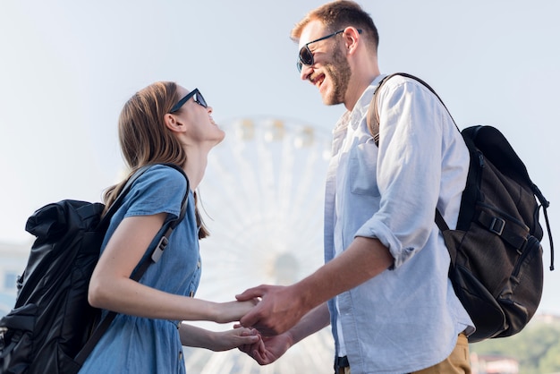 Free photo low angle of tourist couple holding hands