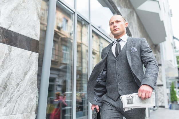 Low angle view of businessman in suit passing by glass window