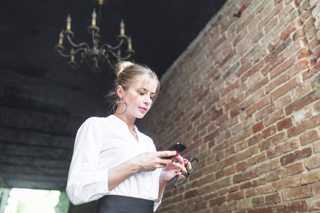 Low angle view of businesswoman using smartphone