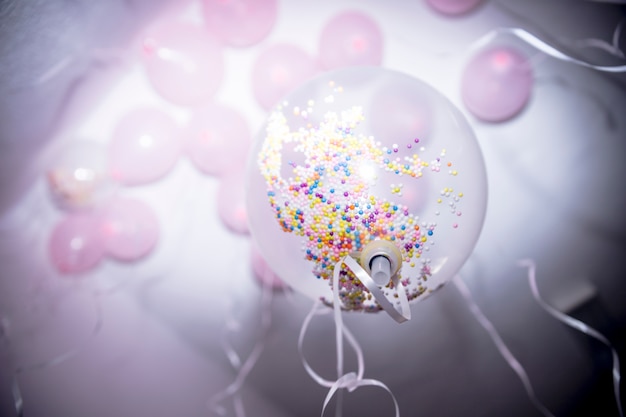 Low angle view of colorful sprinkles in the white balloon on birthday party