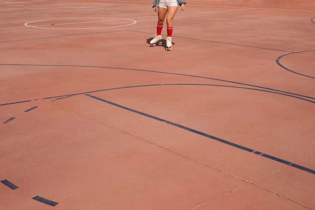 Low angle view of female skater skating on court