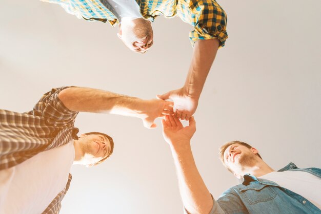 Low angle view of male friends giving high five to each other