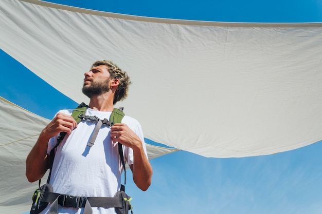 Low angle view of male traveler with backpack looking away