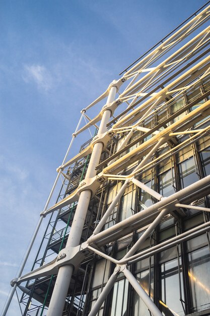 Low angle view of modern building construction under a blue sky and sunlight