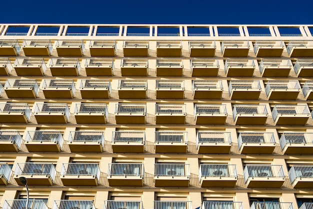 Low angle view of the modern building with balconies against the blue sky