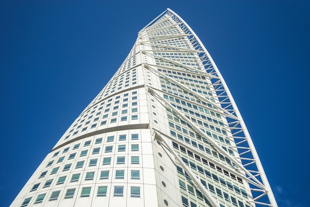 Low angle view of the Turning Torso under a blue sky and sunlight in Malmo in Sweden