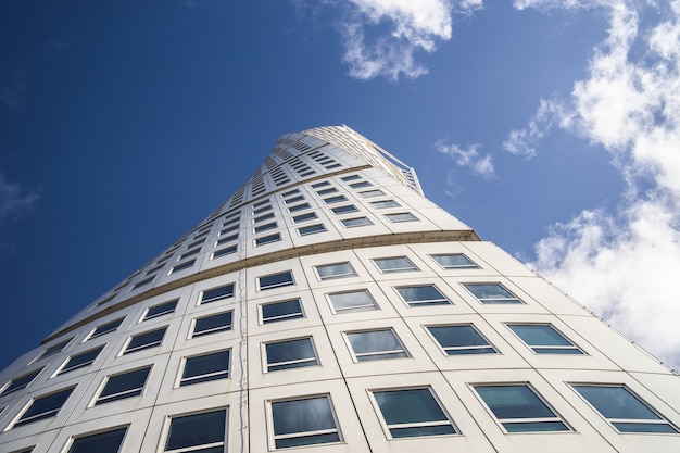 Low angle view of the Turning Torso under a blue sky and sunlight in Malmo in Sweden