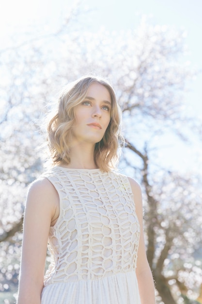 Free photo low angle view woman in white under sunlight