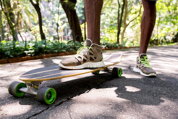 Low angle view of a young male skateboarder's feet in sneakers at park