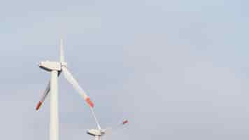 Free photo low angle of wind turbines generating energy