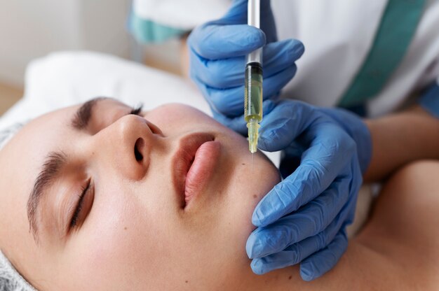 Low angle woman getting face prp treatment