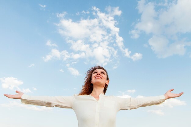 Free photo low angle woman happy to be in nature