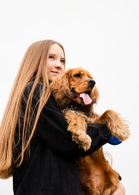 彼女の犬を保持している低角度の女性