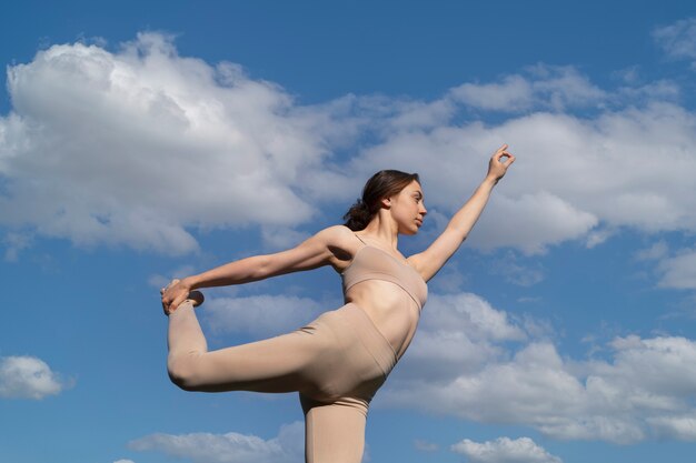 Low angle woman holding her leg up