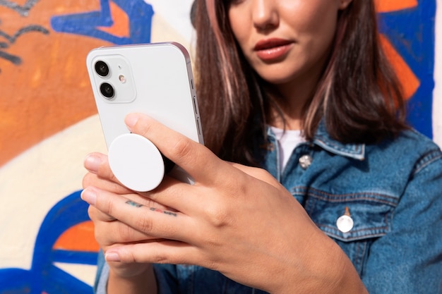 Free photo low angle woman holding smartphone