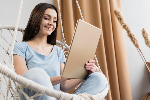 Foto gratuita angolo basso della donna a casa sul tablet